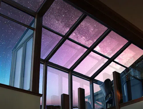 Sunroom Pictured from Inside Looking Up at the Overhead Windows with a Starry Purple Night Sky Outside